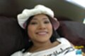 Lying on bed wearing hat