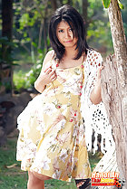 Leaning against tree wearing dress