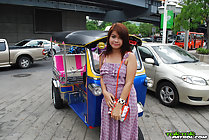 Standing beside tuktuk holding purse